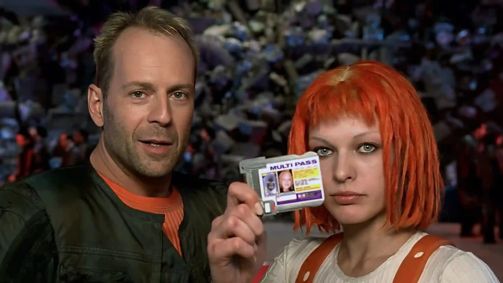 Bruce Willis e Milla Jovovich em O Quinto Elemento, com ela segurando um cartão de identificação e cabelo laranja vibrante
