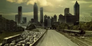 Imagem icônica da série The Walking Dead, mostrando uma estrada em direção à cidade de Atlanta. O lado esquerdo da rodovia está congestionado com carros abandonados, enquanto o lado direito está vazio, simbolizando o colapso da civilização.