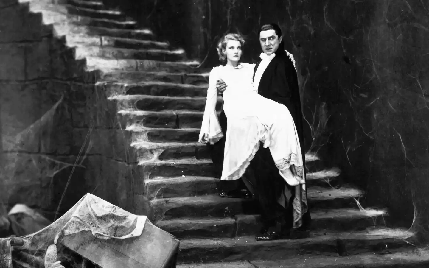 Conde Drácula carrega uma de suas vítimas pelas escadarias sombrias do castelo em uma cena do filme 'Drácula, 1931'. 