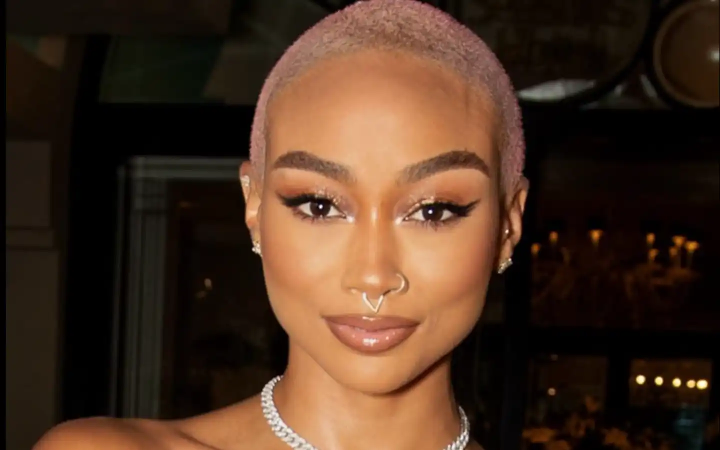 Tati Gabrielle em close, com expressão intensa e maquiagem marcante