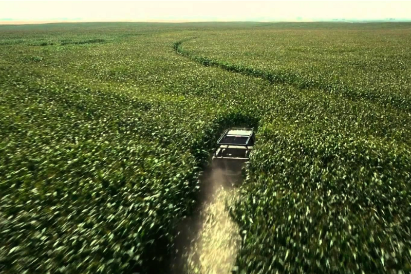 Carro atravessa em alta velocidade um campo extenso de milho