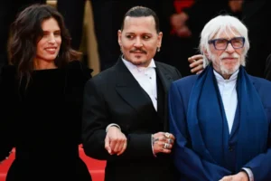 Johnny Depp no tapete vermelho de Cannes em 2023, ao lado da diretora Maïwenn e do produtor, promovendo Jeanne du Barry.