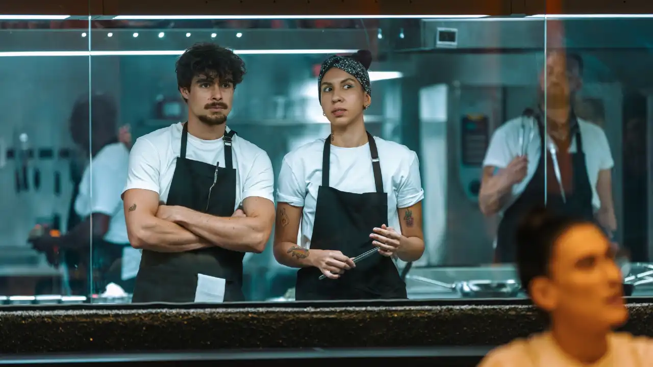 Rafael Vitti (Pedro) e Ademara (Paula) em cena na cozinha do restaurante no filme Caramelo, da Netflix