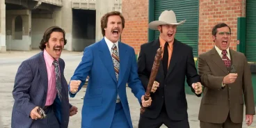 Four men in colorful 1970s suits, standing in a city alleyway, each holding improvised weapons and striking dramatic poses. Promotional scene from the comedy film 'Anchorman: The Legend of Ron Burgundy'. (Credits: TMDB)